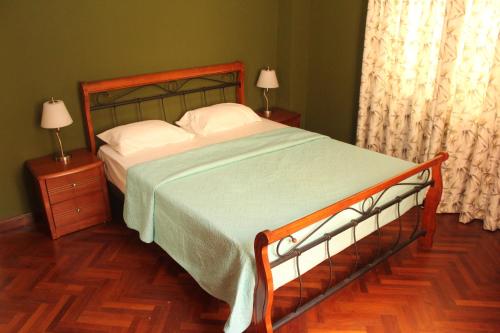 a bedroom with a large bed with a green bedspread at Dauphine in Port Louis