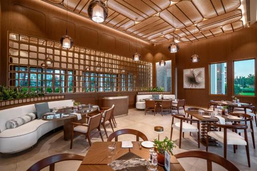 a restaurant with tables and chairs and a couch at Bayou Villas Antalya - Ultra All Inclusive in Antalya