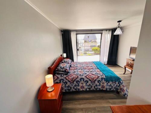 um pequeno quarto com uma cama e uma janela em Maravillosa Casa Con Piscina y Vista al Mar em Concón