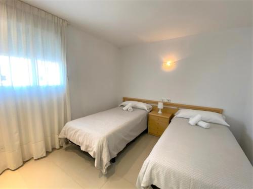 Cette chambre comprend deux lits et une fenêtre. dans l'établissement Coblanca 8-7º 3, à Benidorm