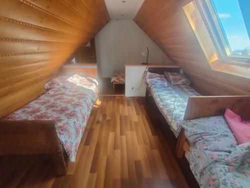 a attic room with two beds and two windows at Noclegi Gal in Odrowąż