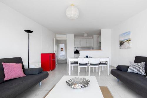 salon z 2 kanapami i czerwoną lodówką w obiekcie PGH N7- 100m de la Plage, Vue Mer & Parking Privé w mieście La Grande-Motte
