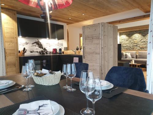 una mesa de comedor con copas de vino y sillas azules en Davos, Residenz Meierhof, Chasa Hubertus, en Davos