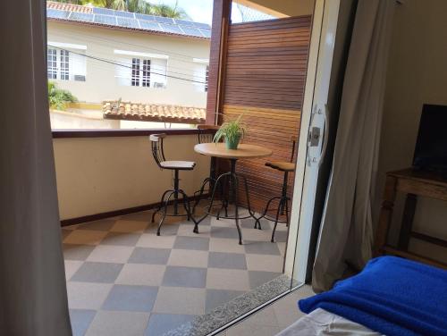 a room with a balcony with a table and chairs at Andorinhas Suites in Búzios