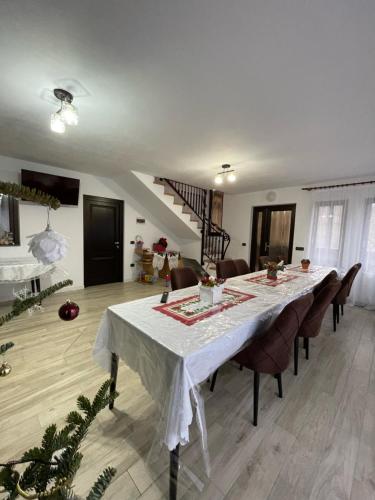 uma sala de jantar com uma mesa longa e cadeiras em Vila Hojda em Moisei