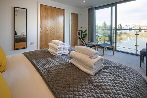 a bedroom with a pile of towels on a bed at Minety Lake 43, Green Haven in Somerford Keynes