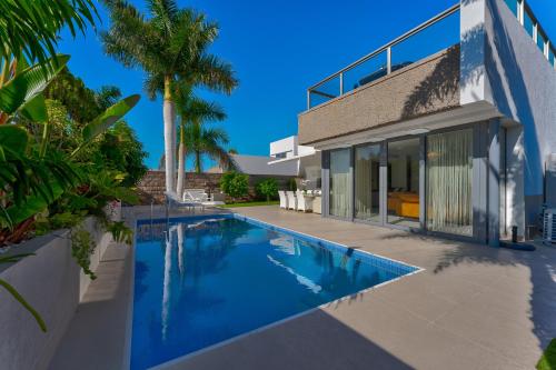 a swimming pool in front of a house at El Duque Private Lux Villa in Adeje