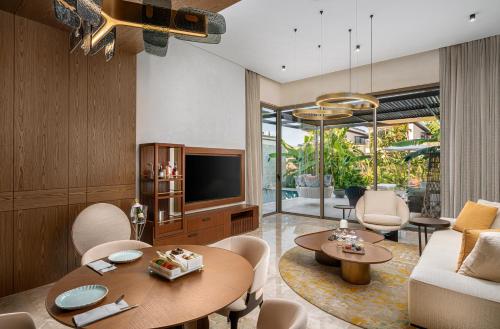 a living room with a table and a tv at Bayou Villas Antalya - Ultra All Inclusive in Antalya