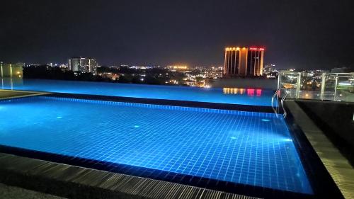 a swimming pool on top of a building at night at Comfy Studio Kuching in Kuching