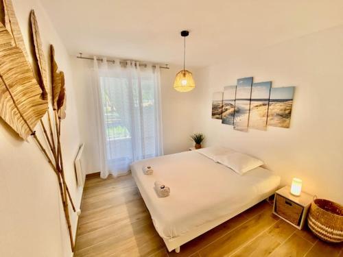 1 dormitorio con cama blanca y ventana en Les Dunes d'Or N10, en La Grande-Motte