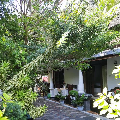 a building with trees and plants in front of it at Susee Villa in Bentota