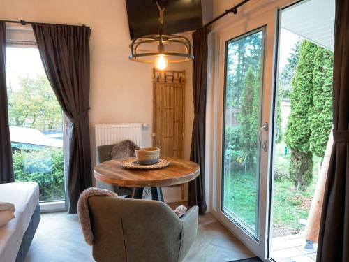 Zimmer mit einem Tisch und einem großen Fenster in der Unterkunft zu Jeddelohs Bungalows & Apartments -Adult friendly in Gladenbach