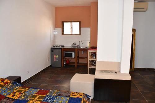 a small room with a kitchen and a bed in it at Studio Assiba 1 in Cotonou