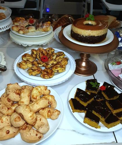 a table topped with plates of desserts and cakes at Hotel Girassol Plaza in Palmas