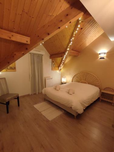 - une chambre avec un grand lit et des plafonds en bois dans l'établissement Appartement plein centre village, vue montagnes, proximité immédiate lac, à Doussard