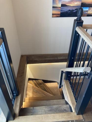a wooden staircase with a wooden railing in a room at Swallows Nest in Bude