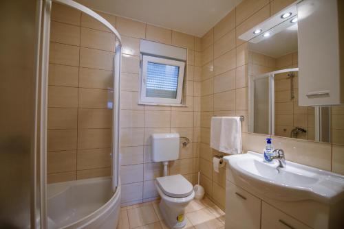 a bathroom with a toilet and a sink and a shower at Kuća- VILLA EVA in Široki Brijeg