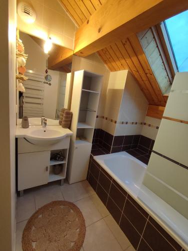 une salle de bain avec un lavabo et une baignoire dans l'établissement Appartement plein centre village, vue montagnes, proximité immédiate lac, à Doussard