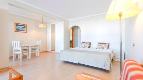 1 dormitorio con 1 cama y comedor en Alfagar Cerro Malpique, en Albufeira