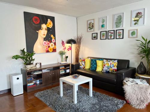 a living room with a black couch and a table at Cozy family room At 103 condominium 2 on nimman 12 in Chiang Mai