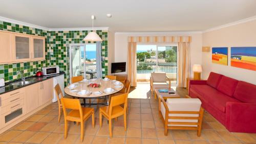 a kitchen and a living room with a red couch at Alfagar Cerro Malpique in Albufeira