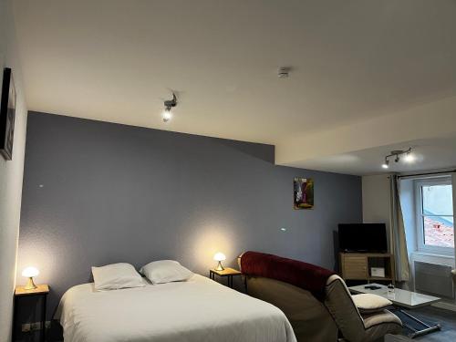 - une chambre avec 2 lits, une chaise et une télévision dans l'établissement Le Petit Nicolas et Parking, à La Rochelle