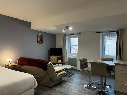 une chambre d'hôtel avec un lit, un bureau et des chaises dans l'établissement Le Petit Nicolas et Parking, à La Rochelle