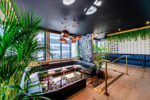 a room with a couch and some plants at The Rockefeller Hotel by NEWMARK in Cape Town