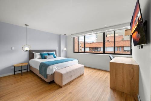 um quarto com uma cama e uma grande janela em Build it in Bogotá - Premium Coliving em Bogotá