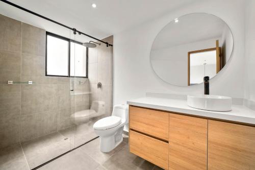 a bathroom with a sink and a toilet and a mirror at Build it in Bogotá - Premium Coliving in Bogotá
