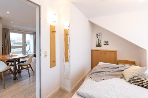 een slaapkamer met een bed en een eetkamer bij M3 - Apartmenthaus Marienburger Str 4 - FERIENDOMIZIL HOLLICH in Grömitz