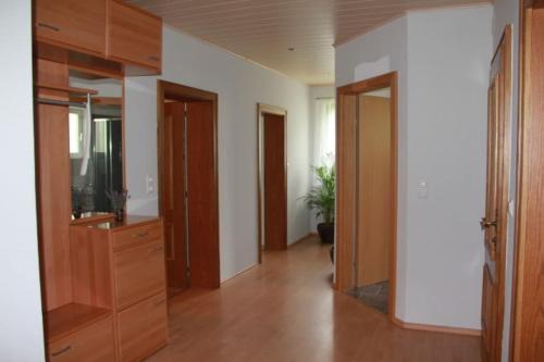 una sala de estar con TV y armarios de madera. en Gemütliches Bergappartement mit Seeblick, en Zödl