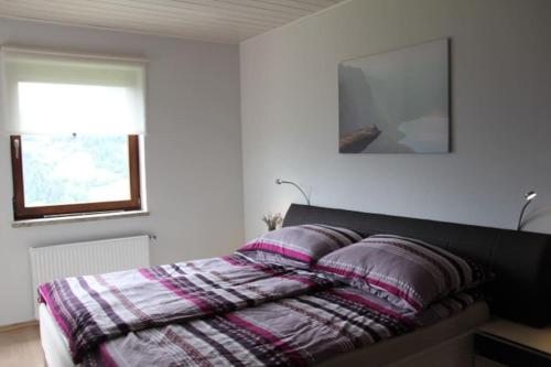 1 dormitorio con 1 cama con 2 almohadas en Gemütliches Bergappartement mit Seeblick, en Zödl