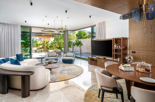 an open living room with a tv and tables and chairs at Bayou Villas Antalya - Ultra All Inclusive in Antalya