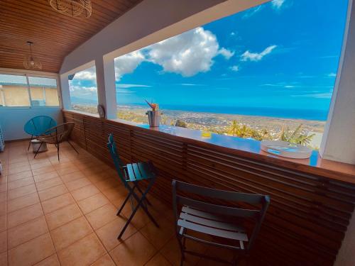 a bar with chairs and a view of the ocean at La Caza Léo - 120m² - Piscine vue sur mer in Étang-Salé