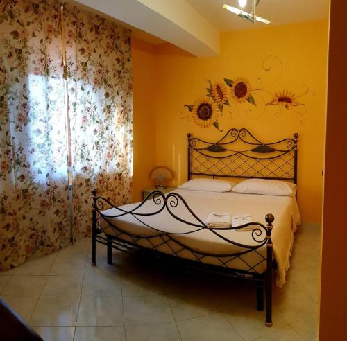 a bedroom with a bed with a flower mural on the wall at DiVino in Spinoso