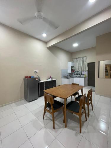 a kitchen and dining room with a wooden table and chairs at TDH Homestay Arau FREE Wifi in Arau