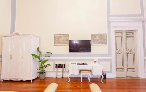 a white room with a desk and a tv on a wall at Villa Royal in Florence
