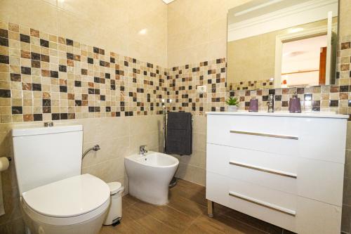 a bathroom with a toilet and a sink at Beautiful Apartment by the Sea in Playa San Juan in Playa de San Juan