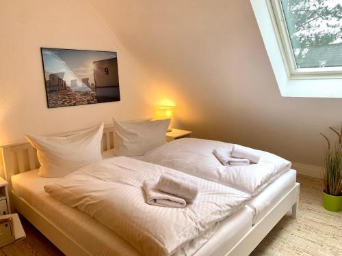 a bedroom with a white bed with towels on it at Ferienwohnung "Laura" in Sankt Peter-Ording