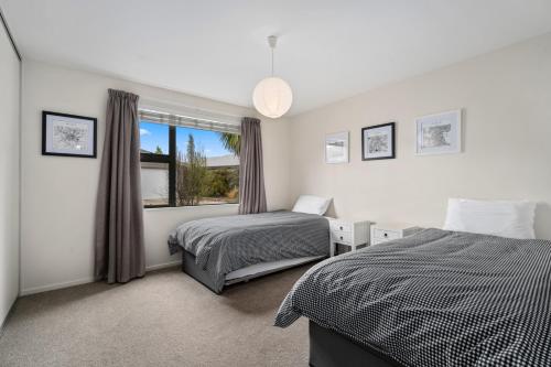 a bedroom with two beds and a window at Urban Oasis - Wanaka Holiday Home in Wanaka