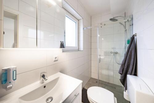 a white bathroom with a sink and a shower at Modernisiertes Altbau 3-Zi Apartment in Rinteln