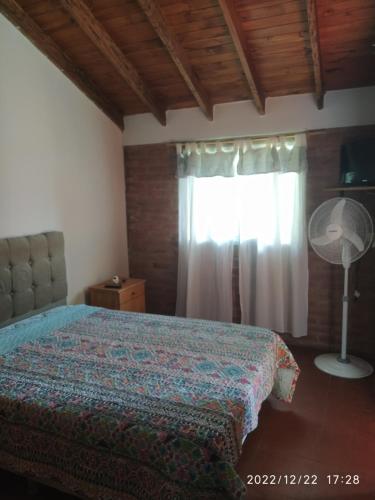 1 dormitorio con cama y ventana en Departamento CatyDay en Mina Clavero