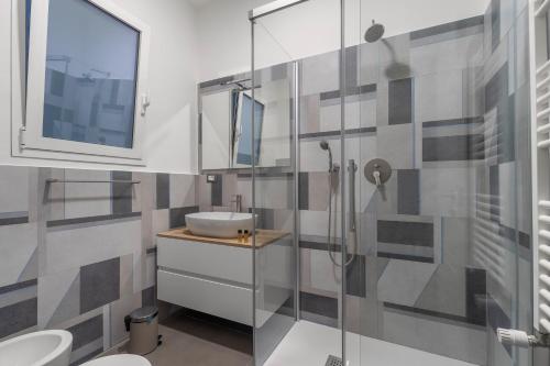 uma casa de banho com um lavatório e uma cabina de duche em vidro. em MolteVolte Rooms em Palermo