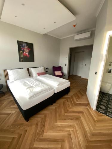 1 dormitorio con 1 cama y suelo de madera en Boutique Hotel Kolbeck en Viena