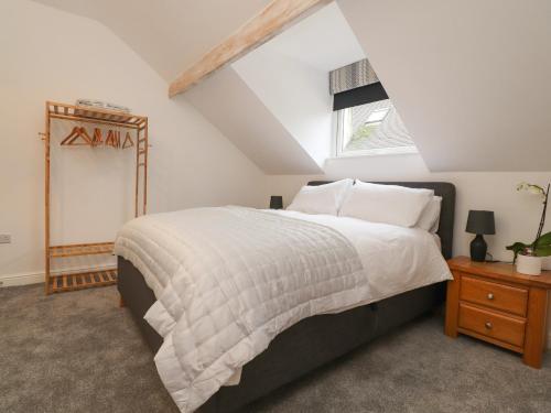 a bedroom with a large bed and a window at The Lodge at Bridgeway in Whalley