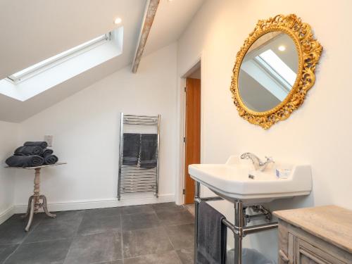 a bathroom with a sink and a mirror on the wall at The Lodge at Bridgeway in Whalley