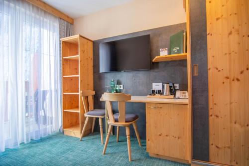 a hotel room with a bar and a tv at Hotel Garni Alpenhof in Ischgl