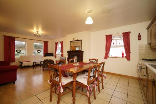 a kitchen and dining room with a table and chairs at Rockgardencottage in Lettermacaward