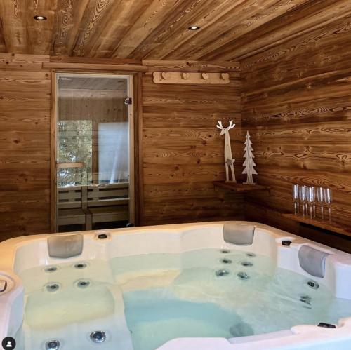a bath tub in a room with wooden walls at Chalet de l'Ours : 4 étoiles-spa-proche des pistes in La Clusaz
